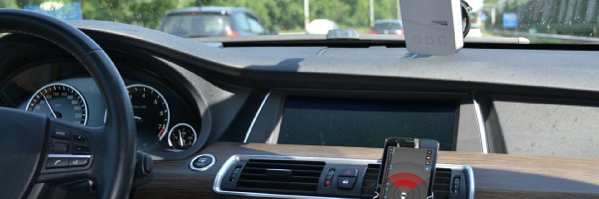 Foto van autodashboard met telefoon en device genaamd FLowradar